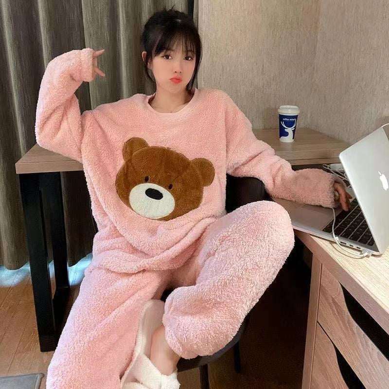 Person wearing a pink teddy bear onesie sitting at a desk with a laptop.