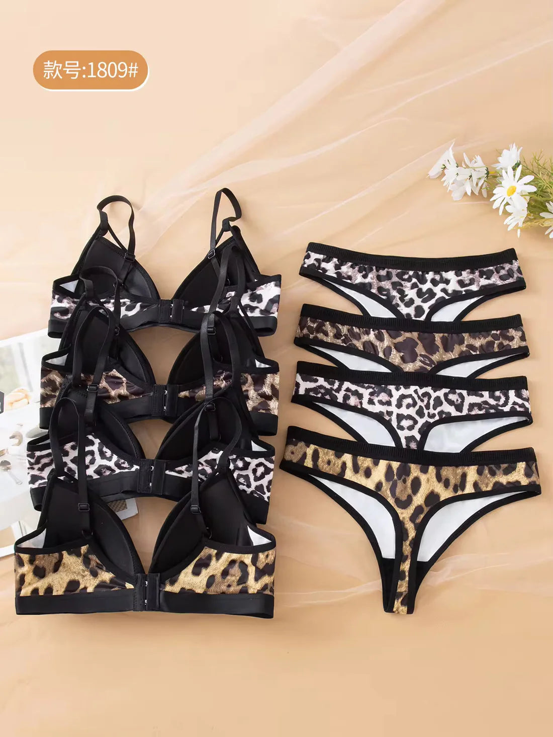 Leopard print lingerie set on a beige background with flowers.