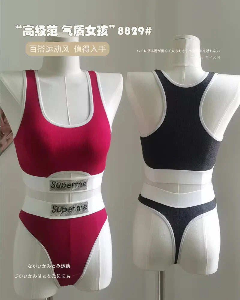 Two mannequins wearing red and black sports bras with Superme branding on a plain background.