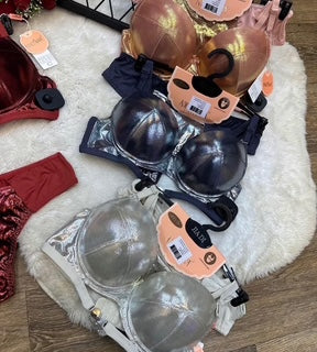 Display of women's lingerie on a white fur rug with a wooden floor.