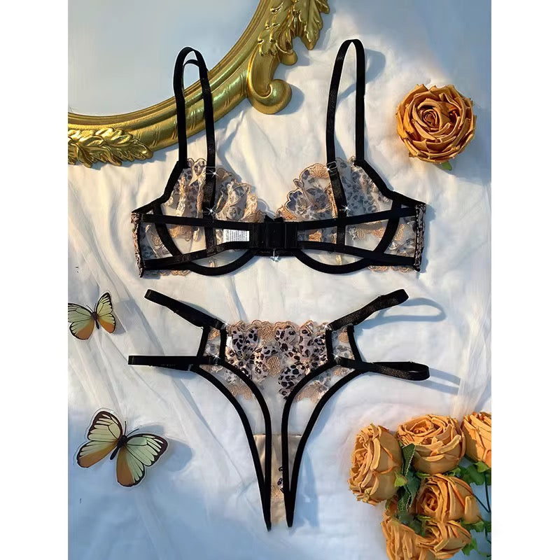Leopard print bikini set with black straps on a decorative background with flowers and a mirror.