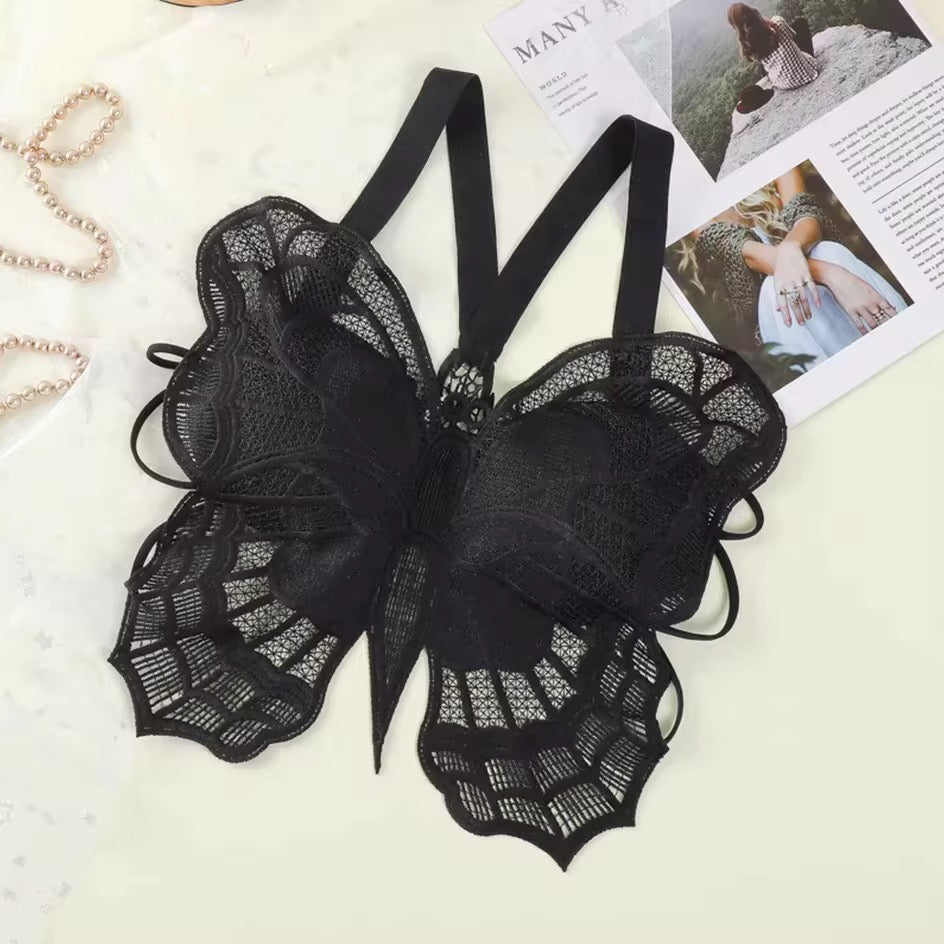 Black lace lingerie set on a light surface with magazines in the background