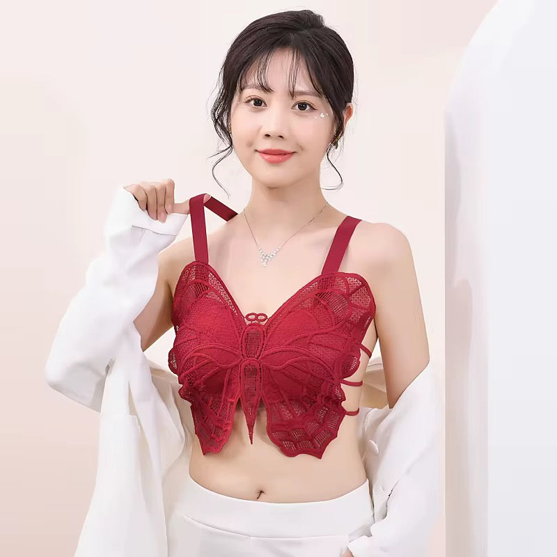 Woman wearing a red lace bralette against a plain background
