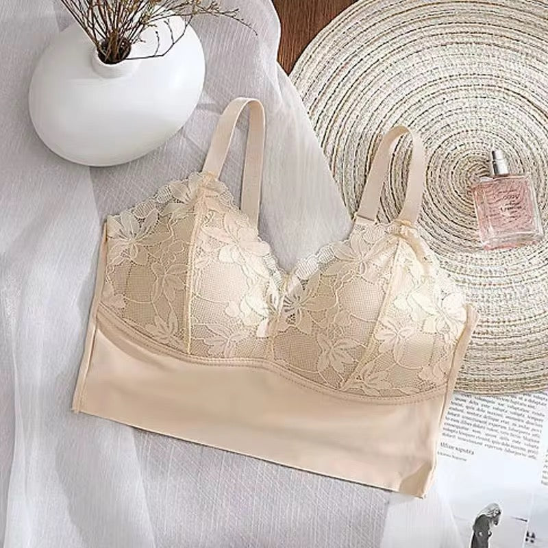 Beige lace bra on a white surface with a decorative background