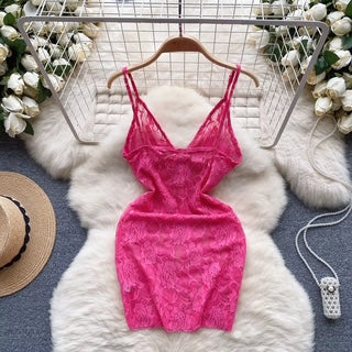 Pink dress on a hanger with a white fur rug and floral decorations in the background