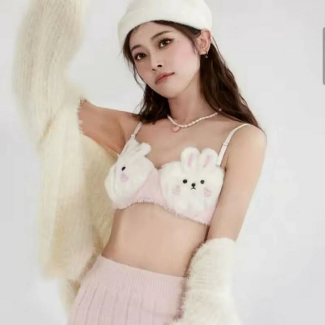 Person wearing a bra with cartoon bunny designs and white gloves on a plain background