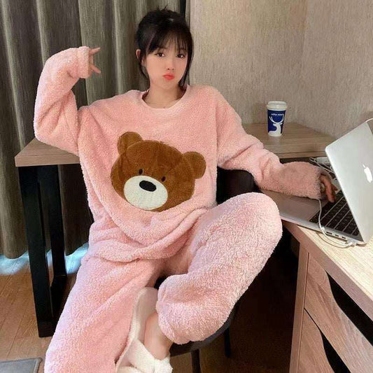 Person wearing a pink teddy bear onesie sitting at a desk with a laptop.