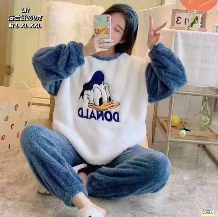 Person wearing a blue and white outfit with a cartoon character design, sitting on the floor.