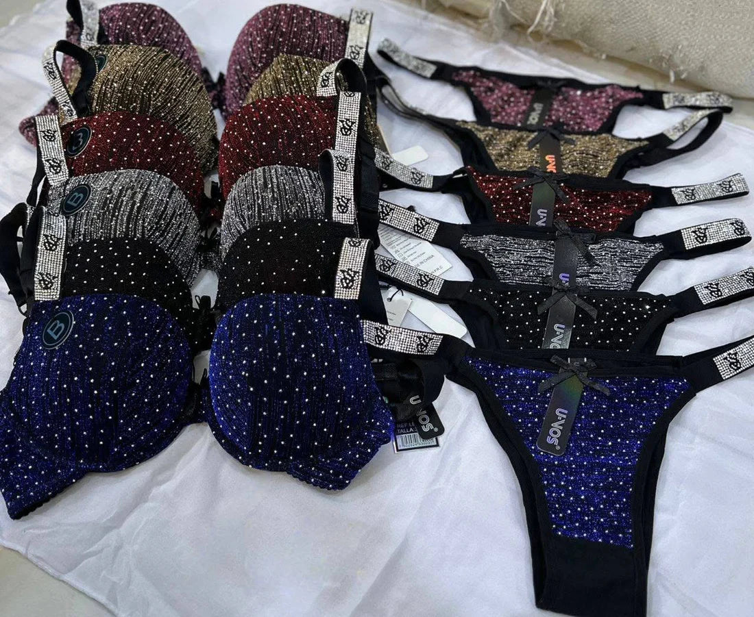 Collection of women's lingerie with rhinestone embellishments on a white surface.