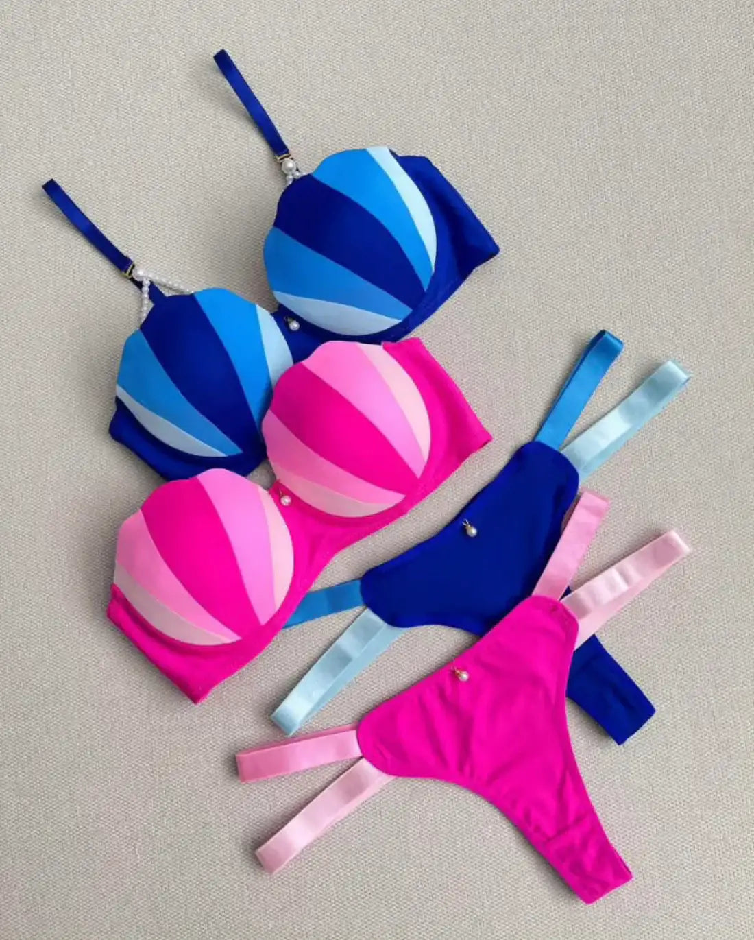 Colorful bikini set with blue and pink patterns on a neutral background