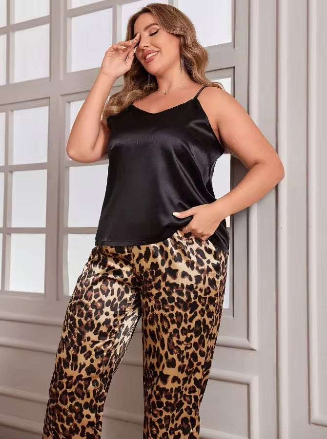 Woman wearing a black satin top and leopard print pants in front of a window.