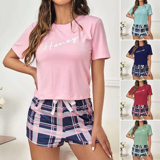 Woman wearing a pink 'Honey' t-shirt and plaid shorts with additional color options displayed.