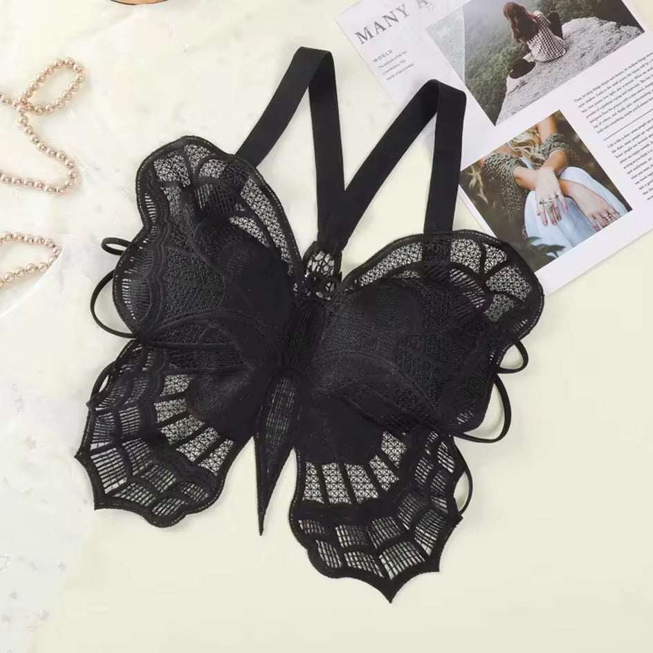 Black lace lingerie set on a light surface with magazines in the background