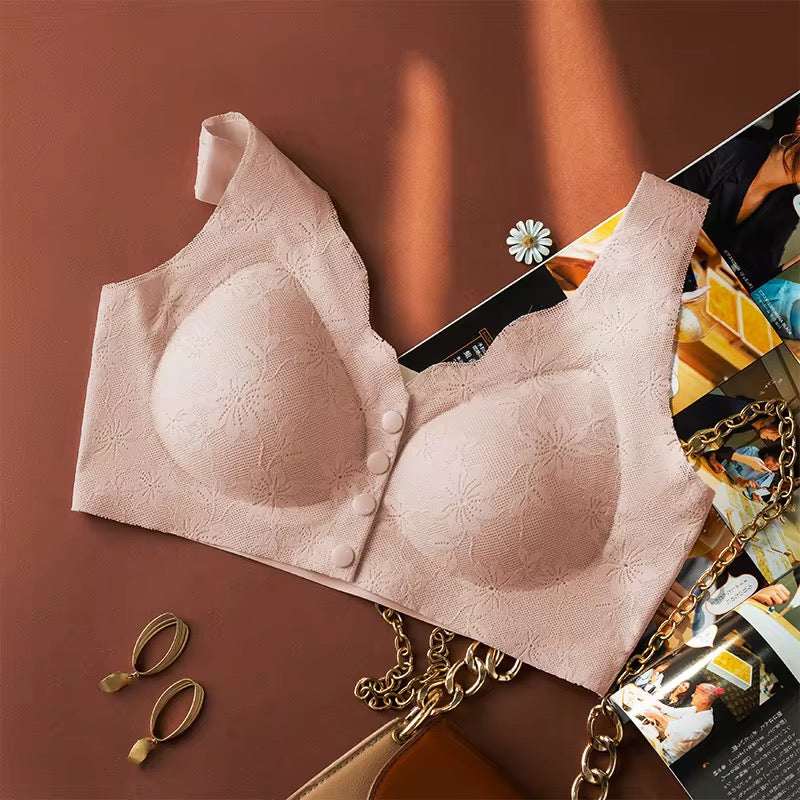 Pink bra with floral lace details on a brown surface with accessories.