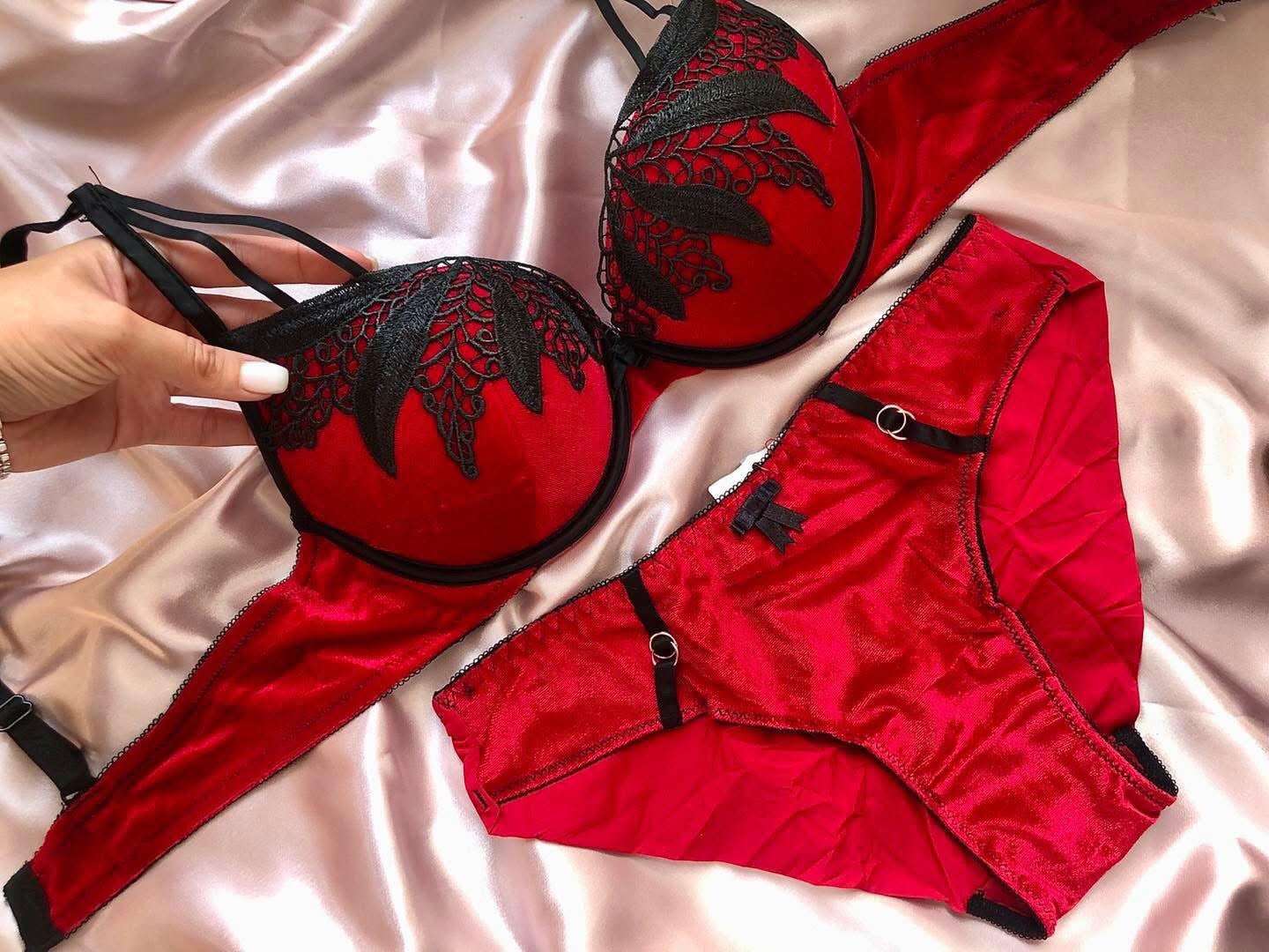 Red lingerie set with black lace details on a satin surface