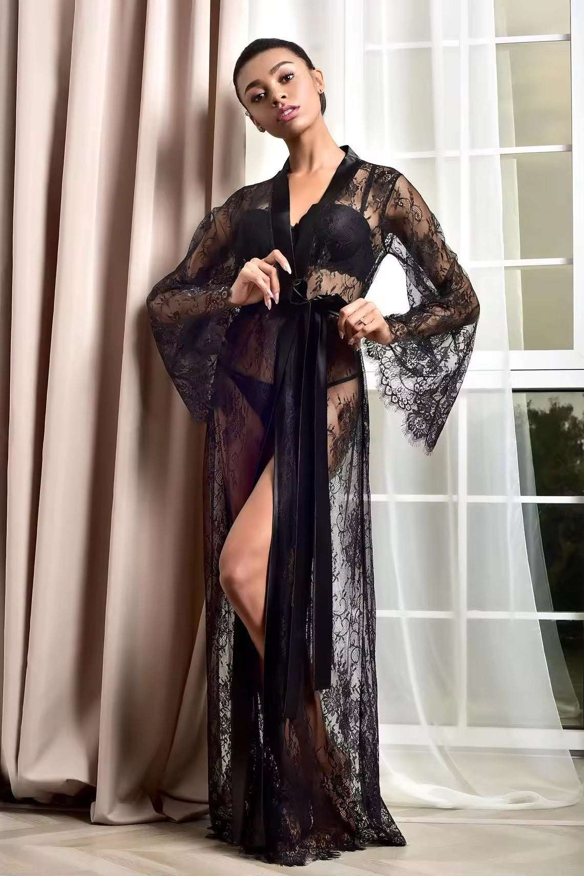 Woman wearing a black lace robe in a room with curtains
