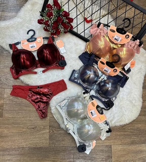 Collection of lingerie items including bras and panties on a wooden floor.