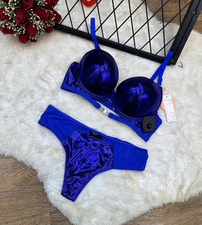 Blue lingerie set on a white surface with a decorative background