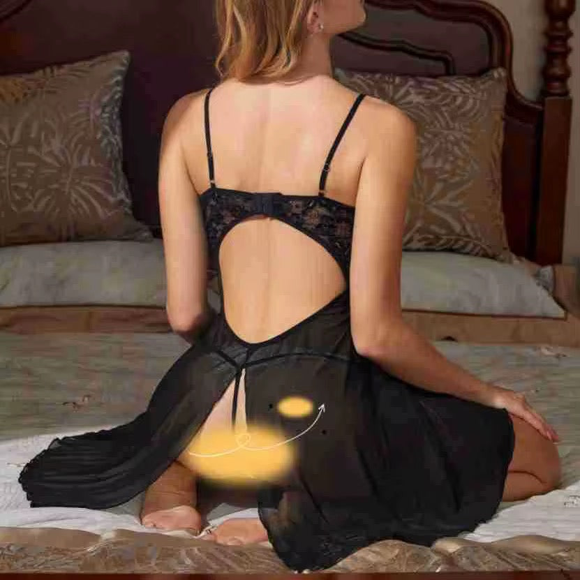 Woman wearing a black lace nightgown sitting on a bed.