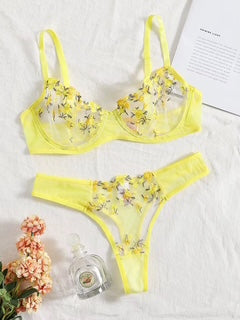 Yellow bikini set with floral embroidery on a white background