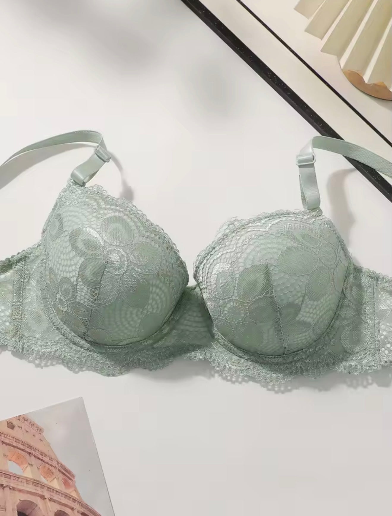 Green lace bra on a white surface with a blurred background