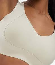 Close-up of a woman wearing a light beige or off-white bra, showing the smooth fabric and molded cup shape.