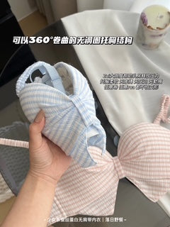 A hand holds a light blue and white striped bralette underarm cup to demonstrate its flexible, bendable structure. A pink and white striped bra is visible in the background on a white surface, with Chinese text overlays describing the product's features.