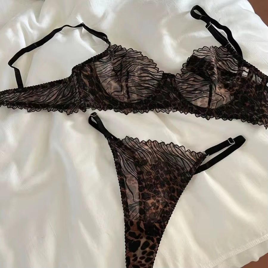 Black lace lingerie set with leopard print on a white fabric background