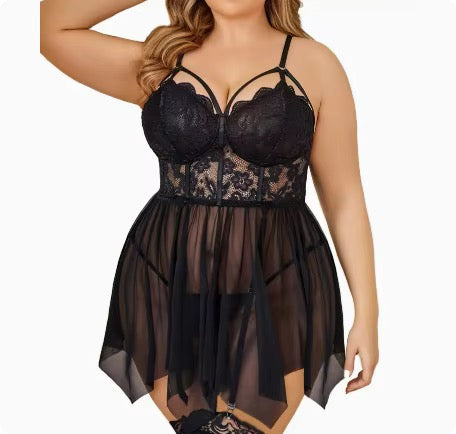 A plus-size model wearing a black lace and sheer mesh babydoll lingerie chemise with underwire cups and thin shoulder straps, shown against a plain white background.