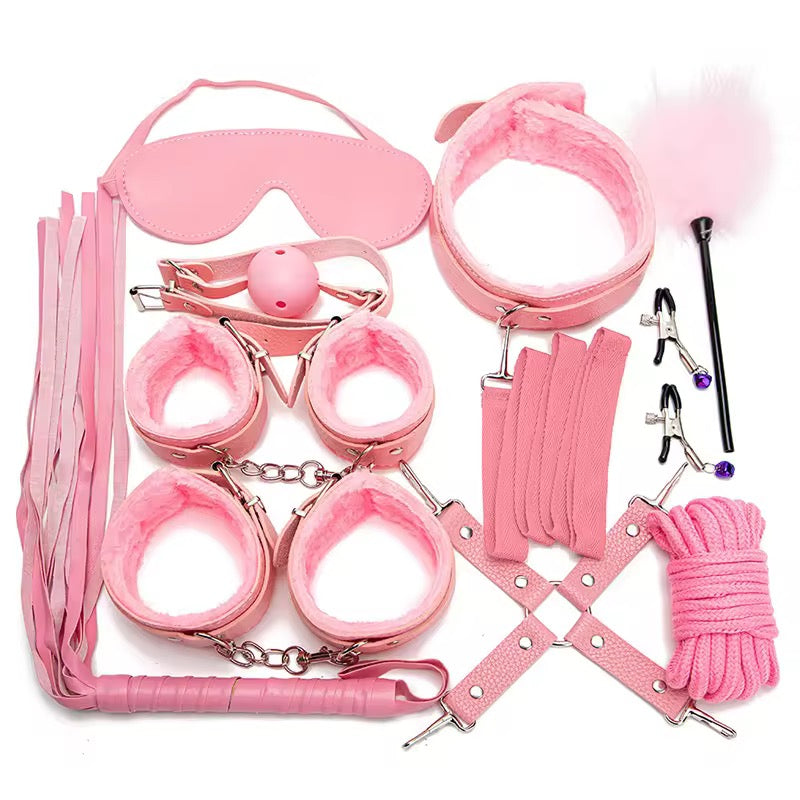 Pink bondage set with various restraints on a white background
