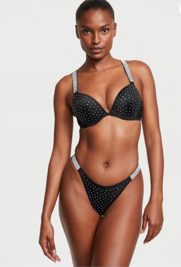 Woman wearing a black polka dot bikini with a white background