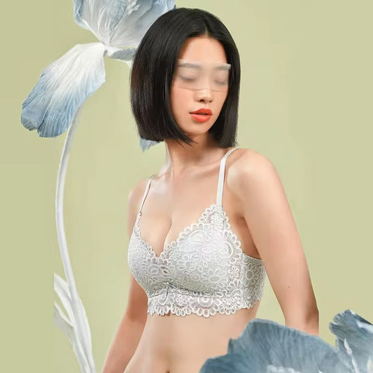 Woman wearing a white lace bra against a light green background