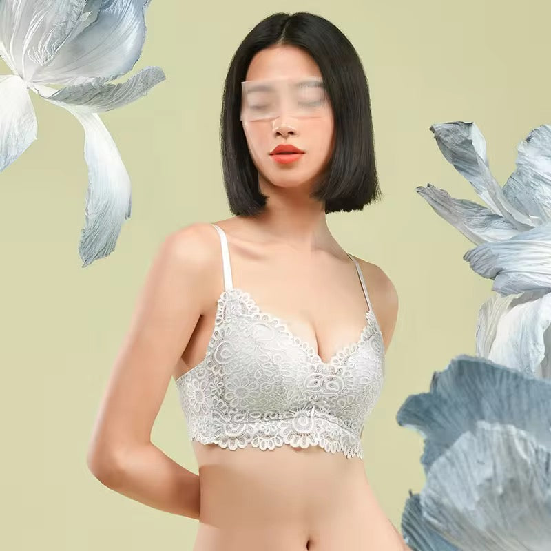 Woman wearing a white lace bralette against a light green background with floral elements.