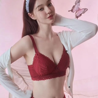 Woman wearing a red bralette against a pink background