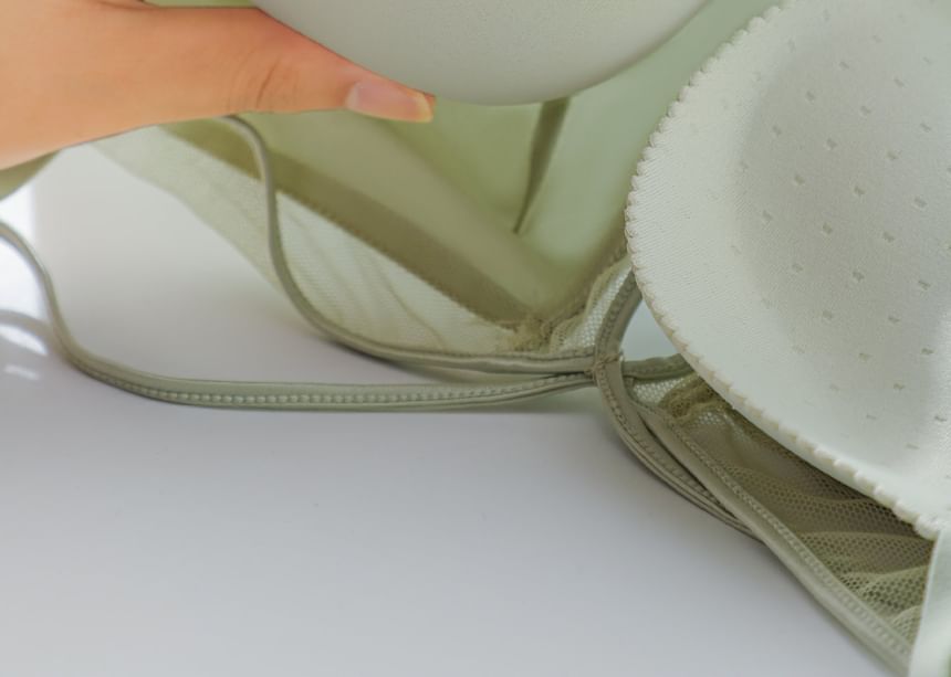 Close-up of a green bra with a white background