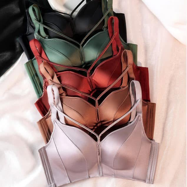 Stack of various colored bras on a white surface