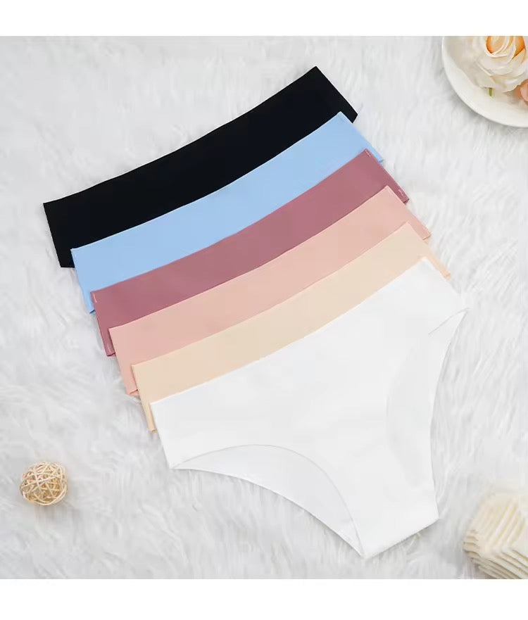 Set of women's underwear in various colors on a textured surface.