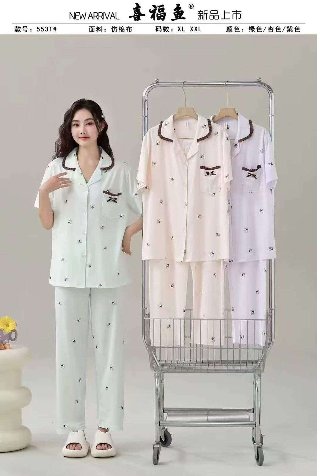 Woman wearing a pajama set next to a shopping cart with more pajama sets on it, against a plain background.